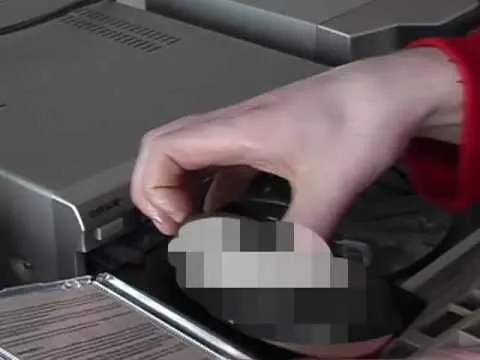 A person adjusting the settings on an electric fan.