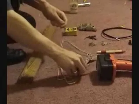 Hand arranging various tools and materials on a carpeted surface.