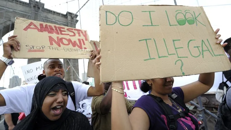 Protesters holding signs advocating for immigration reform and amnesty.