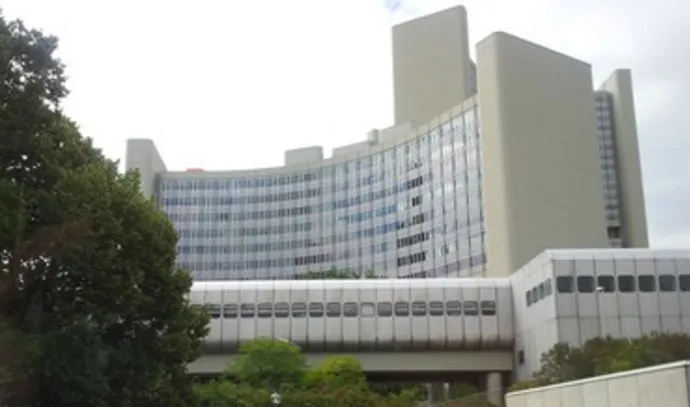 Modern medical building with large glass windows and surrounding greenery.