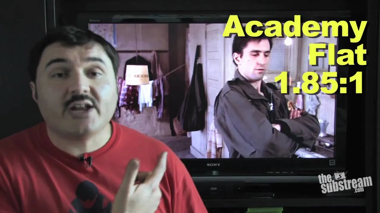 Man gesturing towards a television screen displaying a scene from a film with text overlay about aspect ratio.