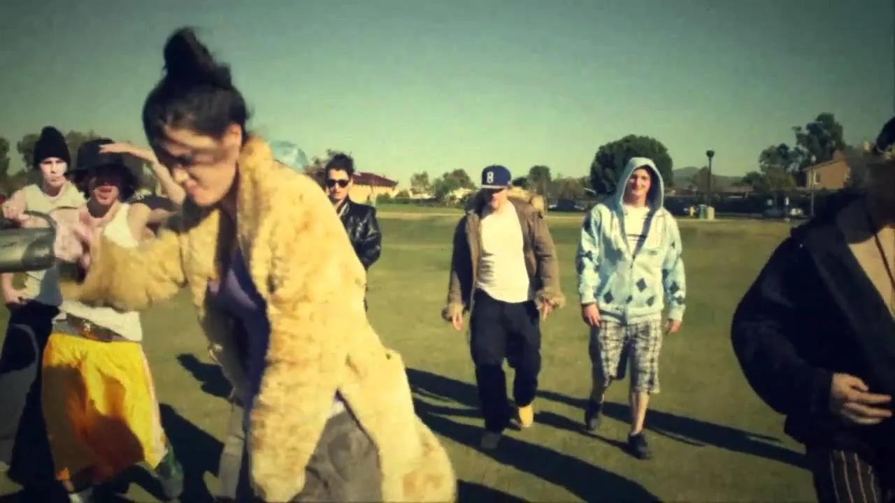 Group of people dancing outdoors in casual attire.
