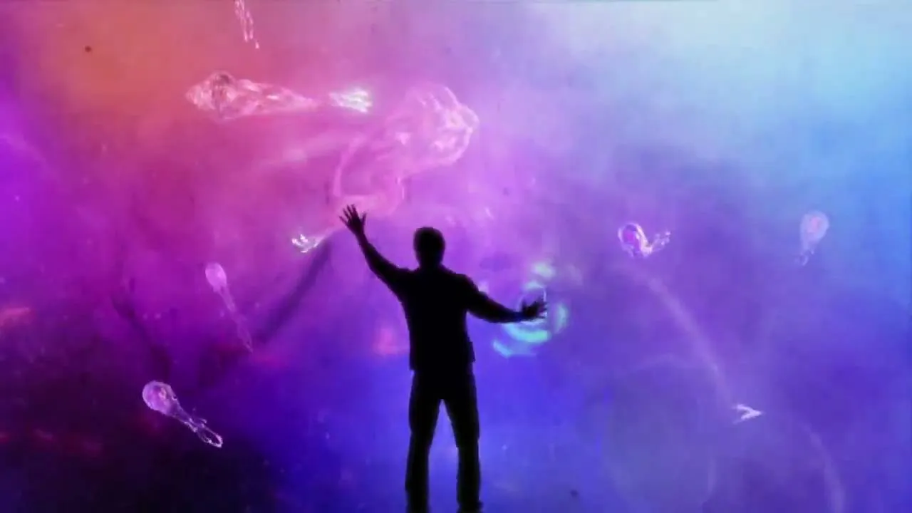Silhouette of a person interacting with colorful abstract visuals.