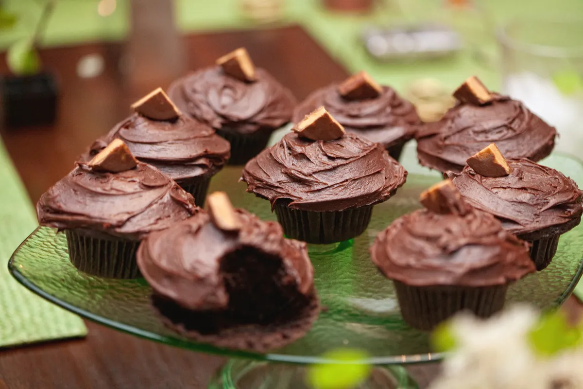 Chocolate cupcakes with frosting and a piece of candy on top.