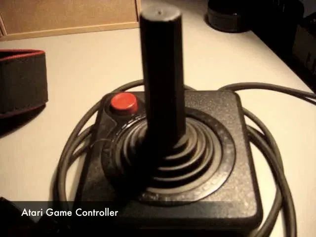Atari game controller with a joystick and button.
