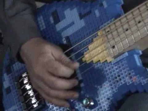 Hand playing a blue, pixelated guitar.