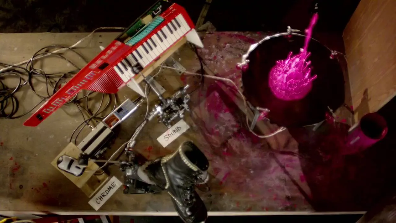 Creative music setup with a keyboard and drum kit, featuring a vibrant splash of color.