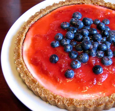 Blueberry and strawberry tart on a white plate.