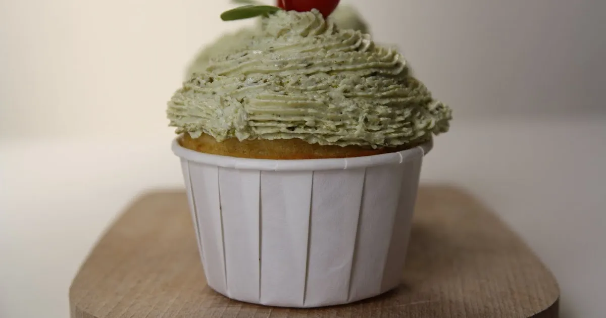 Matcha green tea cupcake with a cherry on top.