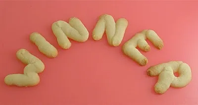 Cookies arranged to spell "WINNER" on a pink background.