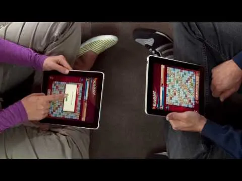 Two people playing a word game on tablets.