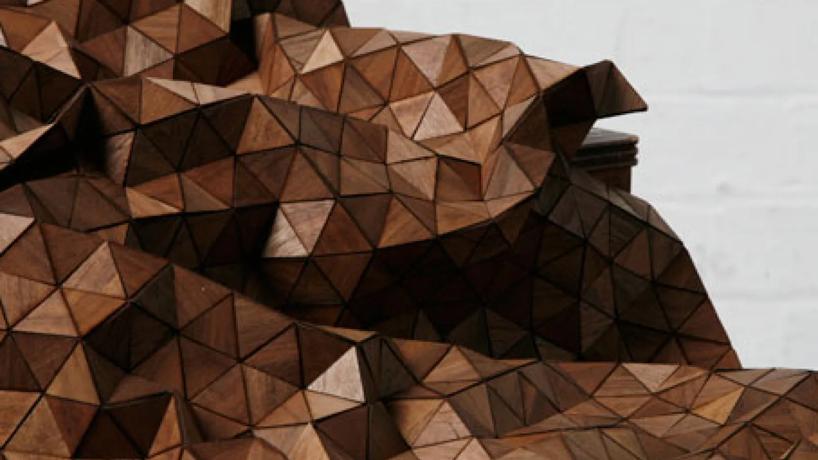 Textured wooden sculpture with triangular patterns.