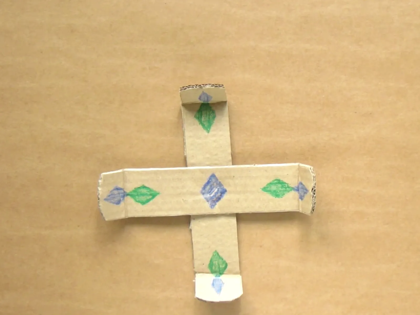 Crafted paper cross with decorative elements.