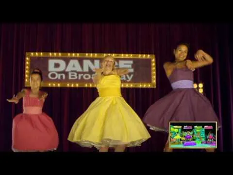 Three dancers in colorful dresses perform on a Broadway-themed stage.