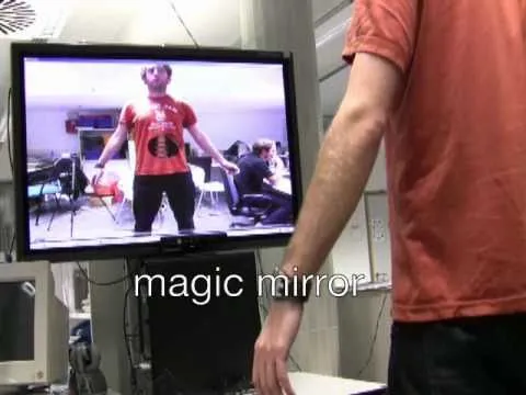 Person interacting with a digital display labeled "magic mirror" in a technology setting.