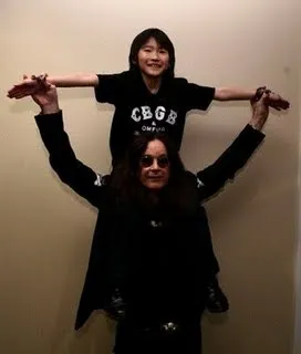 Parent and child having fun, with the child playfully perched on the parent's shoulders.