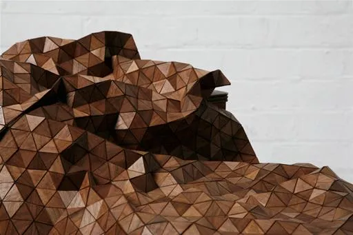 Abstract geometric wood sculpture with triangular facets.