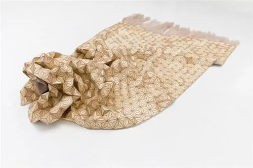 Textured beige fabric draped artistically on a white surface.