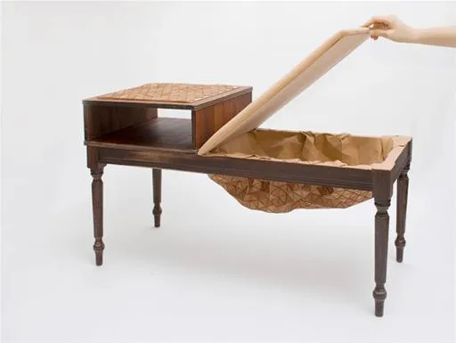 Antique wooden table with a lift-top compartment and woven basket underneath.
