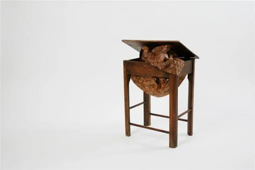 Wooden table with a folded top and decorative elements.