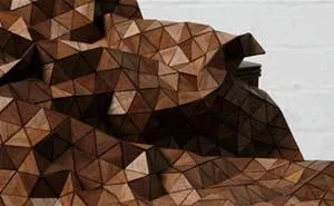 Geometric wooden sculpture with triangular facets.