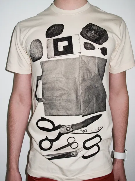 Graphic tee featuring various art supplies and tools.