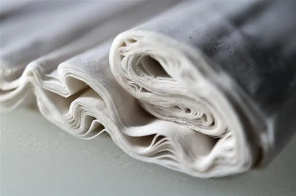 Rolled white fabric on a surface.