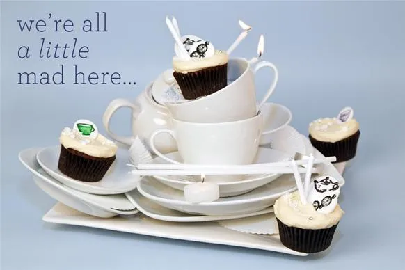 Cupcakes on a stack of white plates with a whimsical quote.