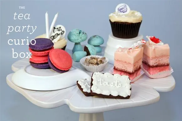 Tea party dessert display featuring a variety of colorful pastries and cupcakes.