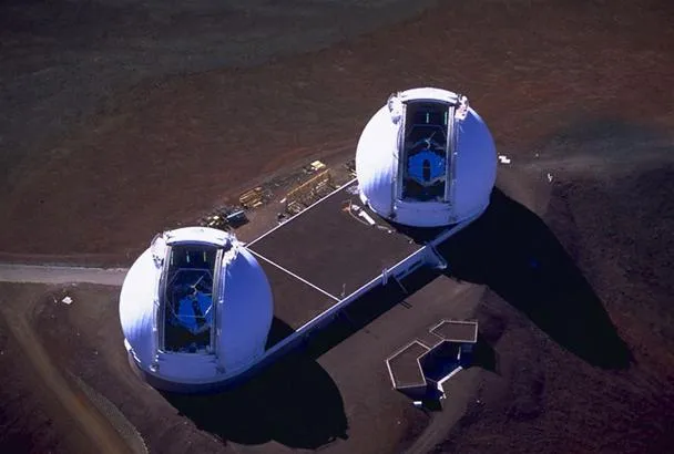 Aerial view of two white spherical structures on a barren landscape.