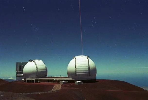 Observatory domes on a mountain under a clear blue sky.