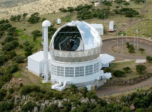 Observatory building with a large dome structure surrounded by greenery.