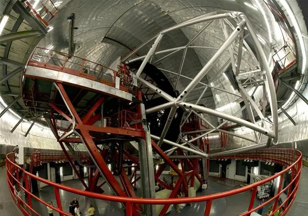 Large astronomical telescope structure inside an observatory.