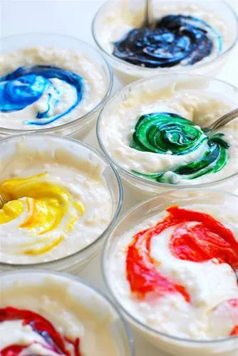 Colorful bowls of frosting in various hues.