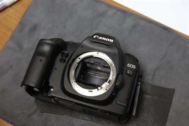 Canon EOS 5D camera on a gray surface.