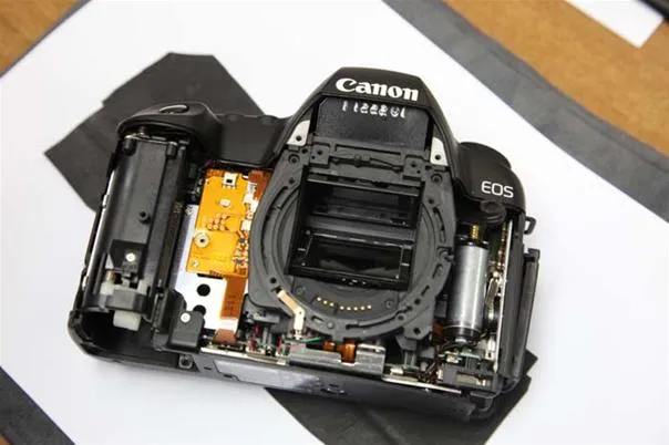 Disassembled Canon EOS camera showing internal components.