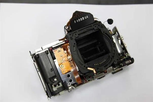 Camera component disassembled on a white surface.