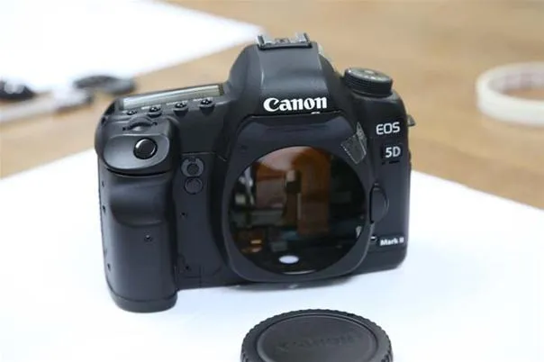 Canon EOS 5D camera body with lens cap removed.