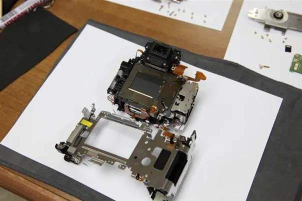 Disassembled camera parts on a work surface.
