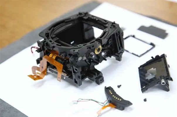 Disassembled camera lens components on a work surface.