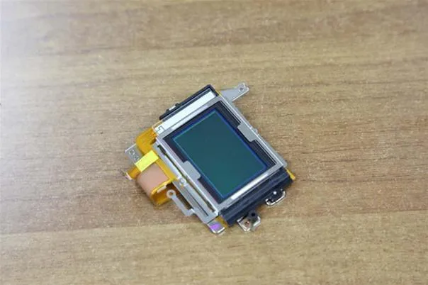 Digital camera image sensor on a wooden surface.