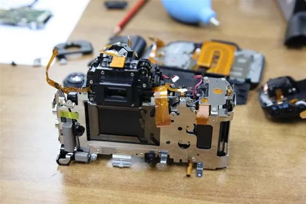 Disassembled camera components on a workbench.