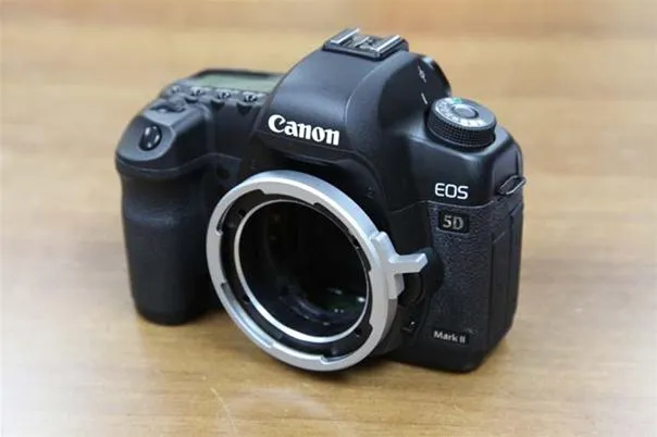 Canon EOS 5D camera on a wooden surface.