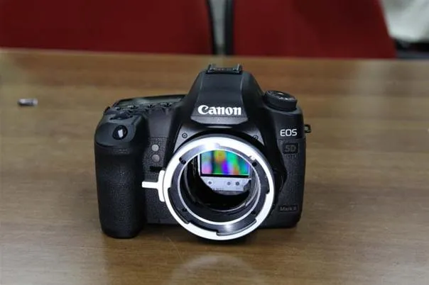 Canon DSLR camera on a wooden table.