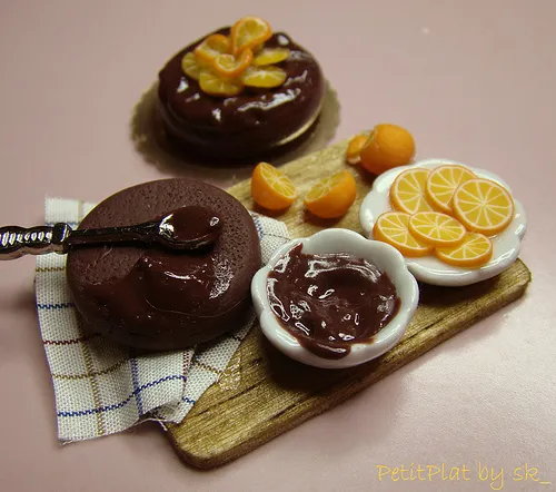 Chocolate desserts with citrus garnishes on a wooden platter.