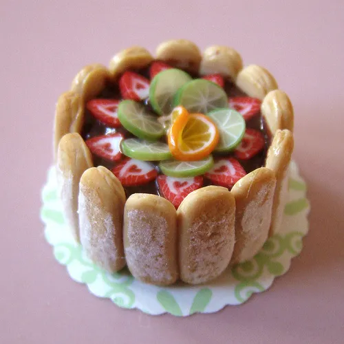 Fruit-topped cake with a decorative border.