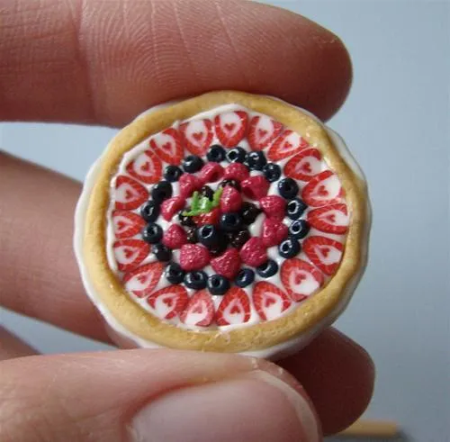 Miniature dessert featuring a colorful fruit tart with intricate designs.