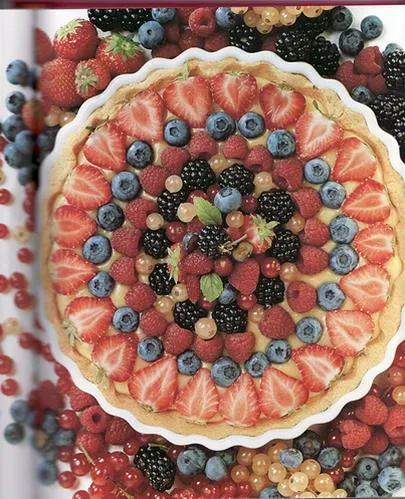 Colorful fruit tart featuring strawberries, blueberries, raspberries, and blackberries.