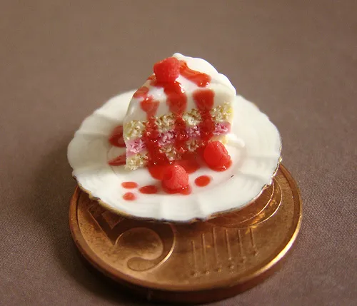 Miniature cake topped with strawberry sauce on a coin.