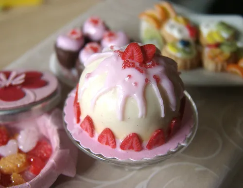 Colorful desserts featuring a strawberry cake, cupcakes, and assorted pastries.